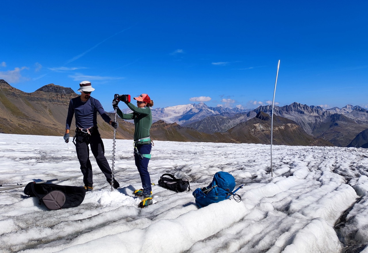 Nachbohren einer Messstange auf dem Griesgletscher (VS). Ein Netzwerk von Pegeln wie rechts im Bild erlaubt die Bestimmung des Verlustes auf der ganzen Gletscherfläche. (Foto: M. Huss)