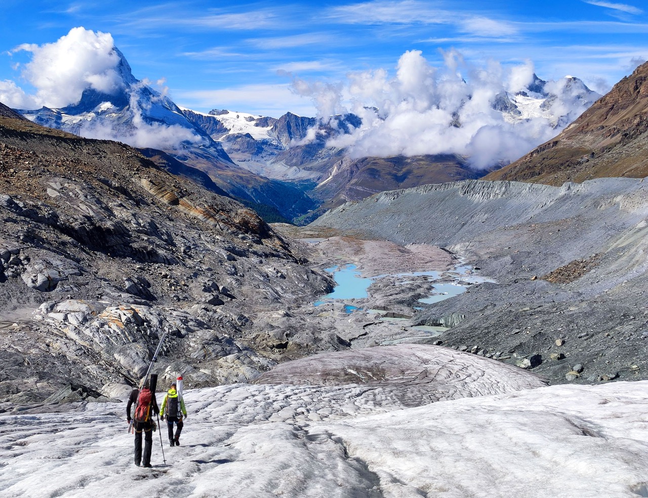 Glaziologen steigen über die zerfallende Zunge des Findelgletschers (VS) ab. Noch vor einem Jahrzehnt waren die leuchtend blauen Gletscherseen von Dutzenden Metern Eis bedeckt. (Foto: M. Huss)