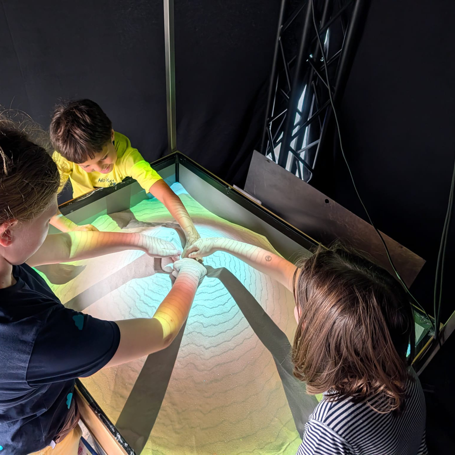Children exploring the AR Sandbox, where they can shape their own landscapes and learn how topography works.